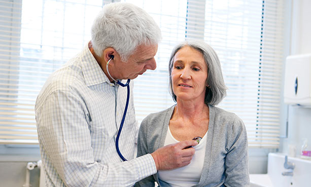 doctor checking patient's heart