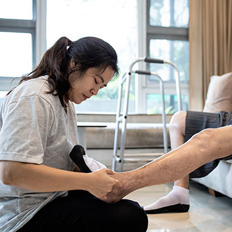asian woman massaging elderly man diabetic foot